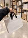 White paper bag with black ribbon handles