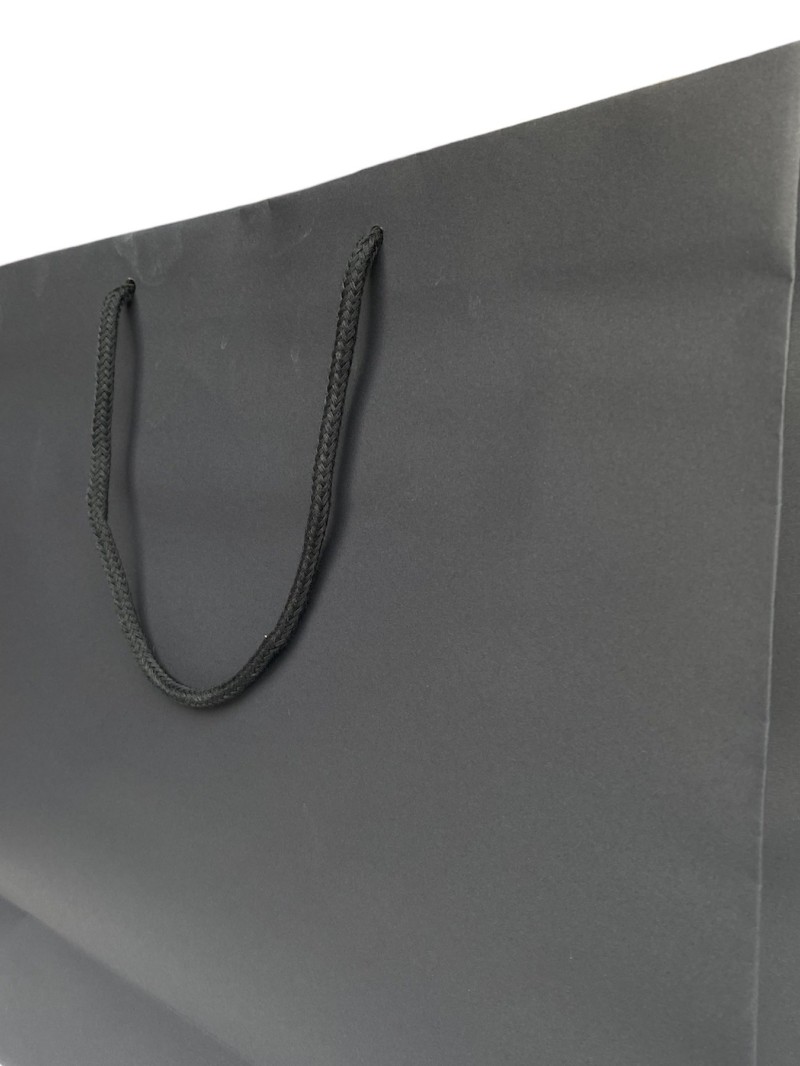 Schwarze Papiertüte mit schwarzen Kordelgriffen